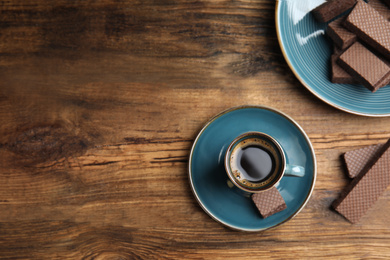 Photo of Breakfast with delicious wafers and coffee on wooden table, flat lay. Space for text