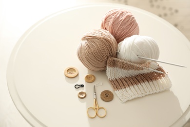 Photo of Yarn balls and knitting accessories on white table. Creative hobby