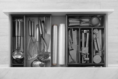 Drawer with stainless steel utensil set, top view. Order in kitchen