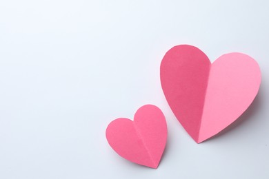 Photo of Pink paper hearts on white background, flat lay. Space for text