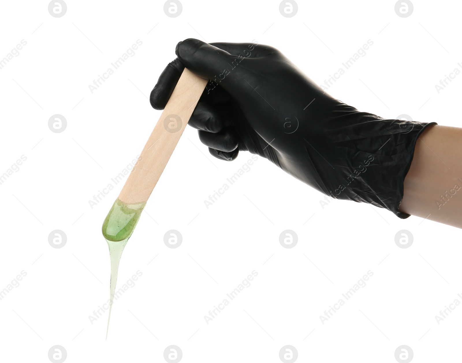 Photo of Woman in gloves holding spatula with hot depilatory wax on white background, closeup