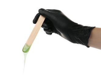 Woman in gloves holding spatula with hot depilatory wax on white background, closeup