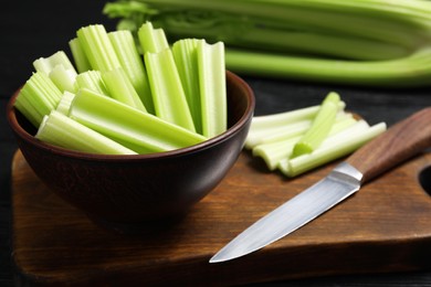 Photo of Fresh cut celery and knife on table, closeup