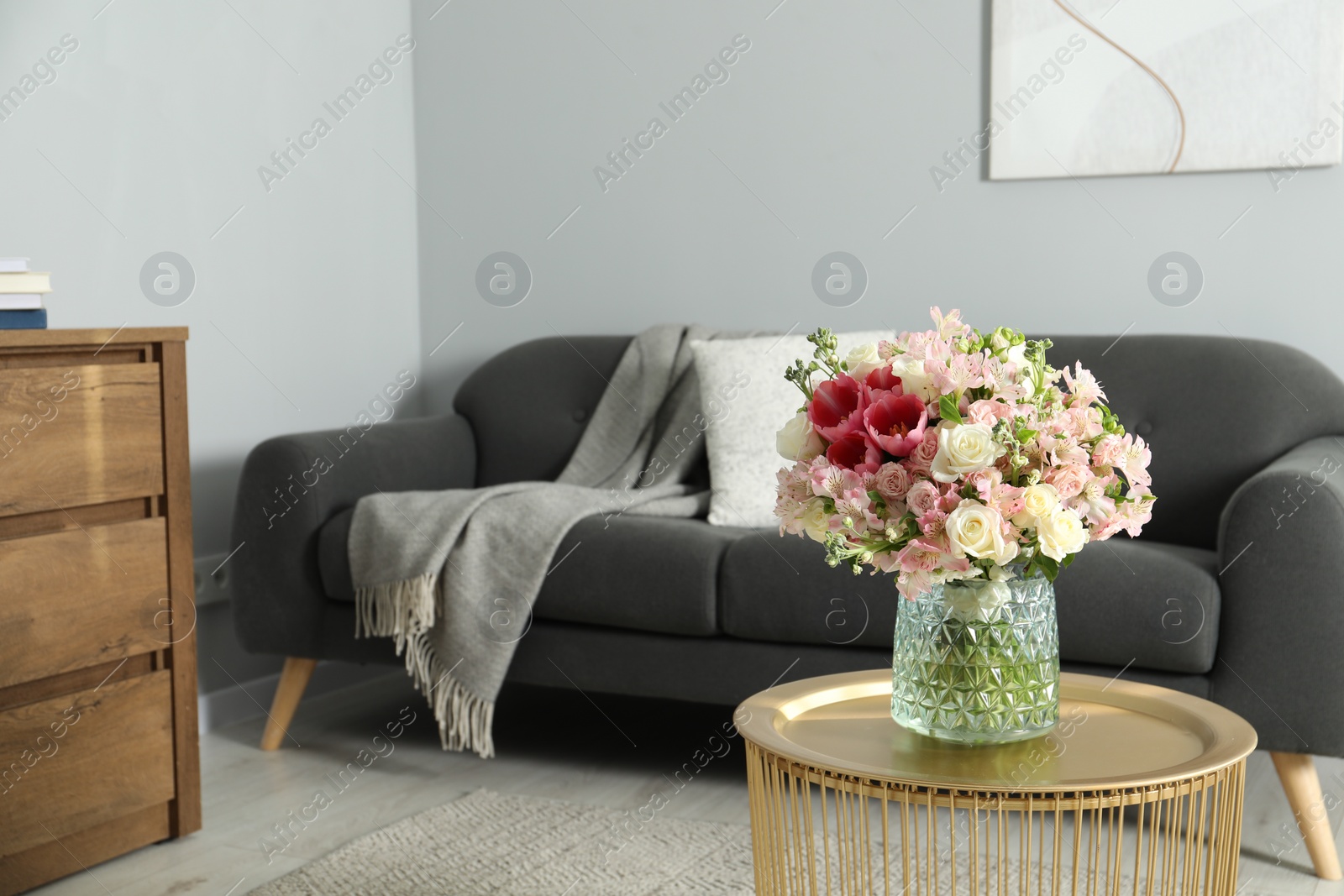 Photo of Beautiful bouquet of fresh flowers on coffee table in room, space for text