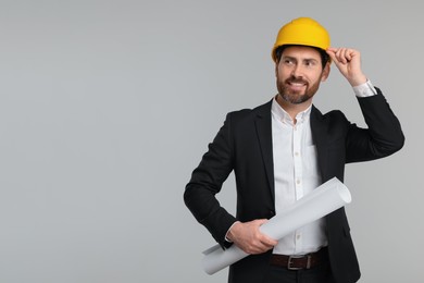 Architect in hard hat with draft on gray background, space for text