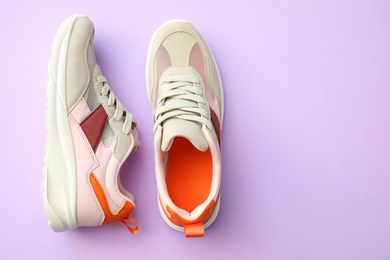 Photo of Pair of stylish shoes on lilac background, top view. Space for text