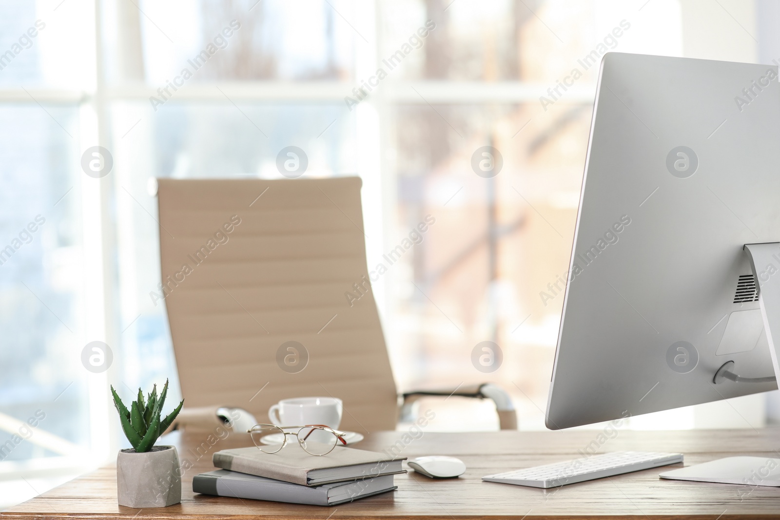 Photo of Computer, notebooks and coffee on table in office