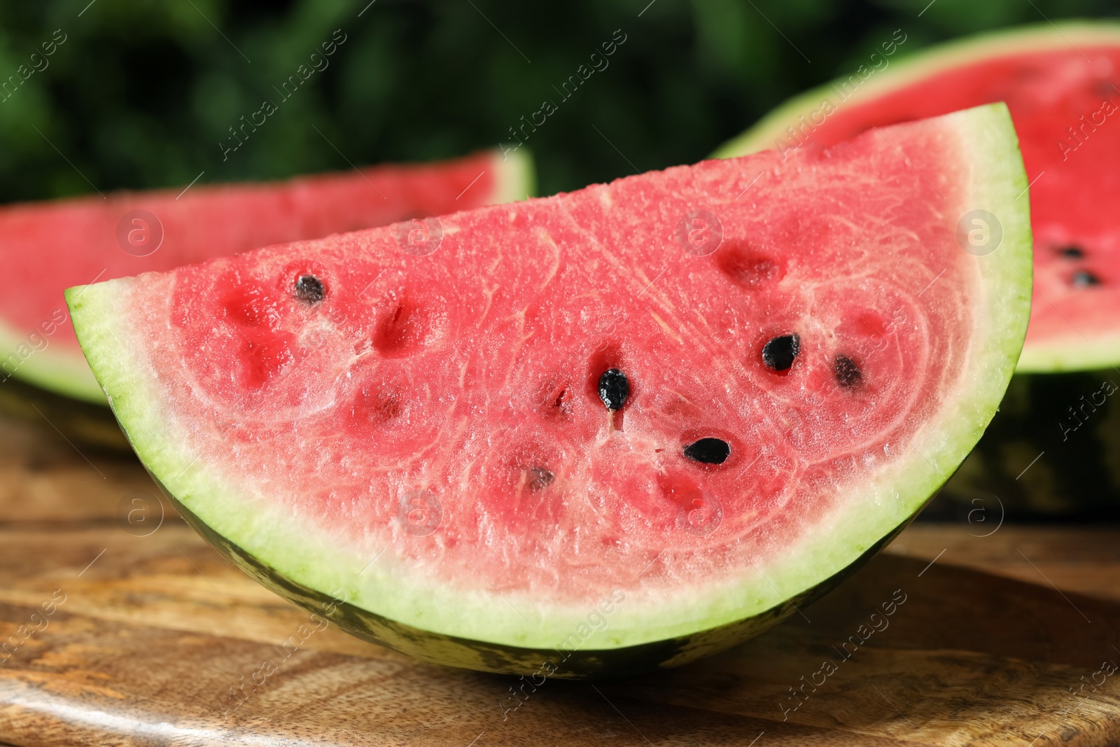 Photo of Delicious fresh watermelon slices on wooden table, closeup