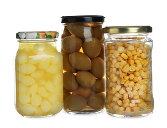 Photo of Glass jars of different pickled vegetables isolated on white