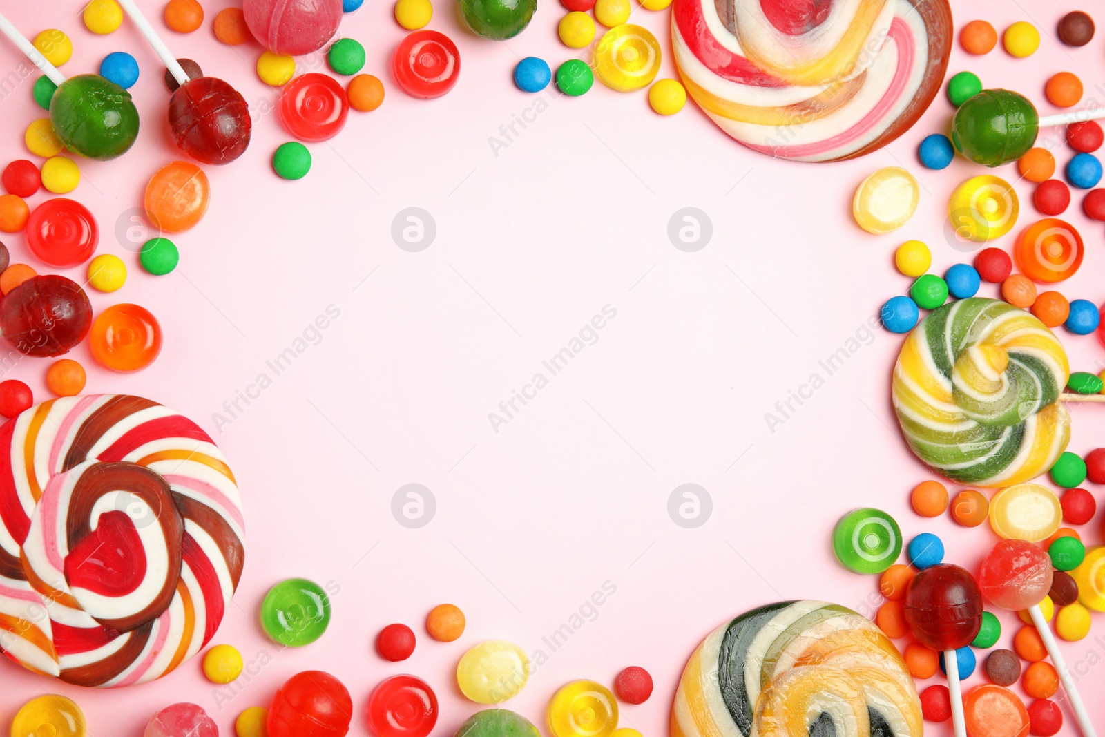 Photo of Flat lay composition with delicious colorful candies and space for text on color background