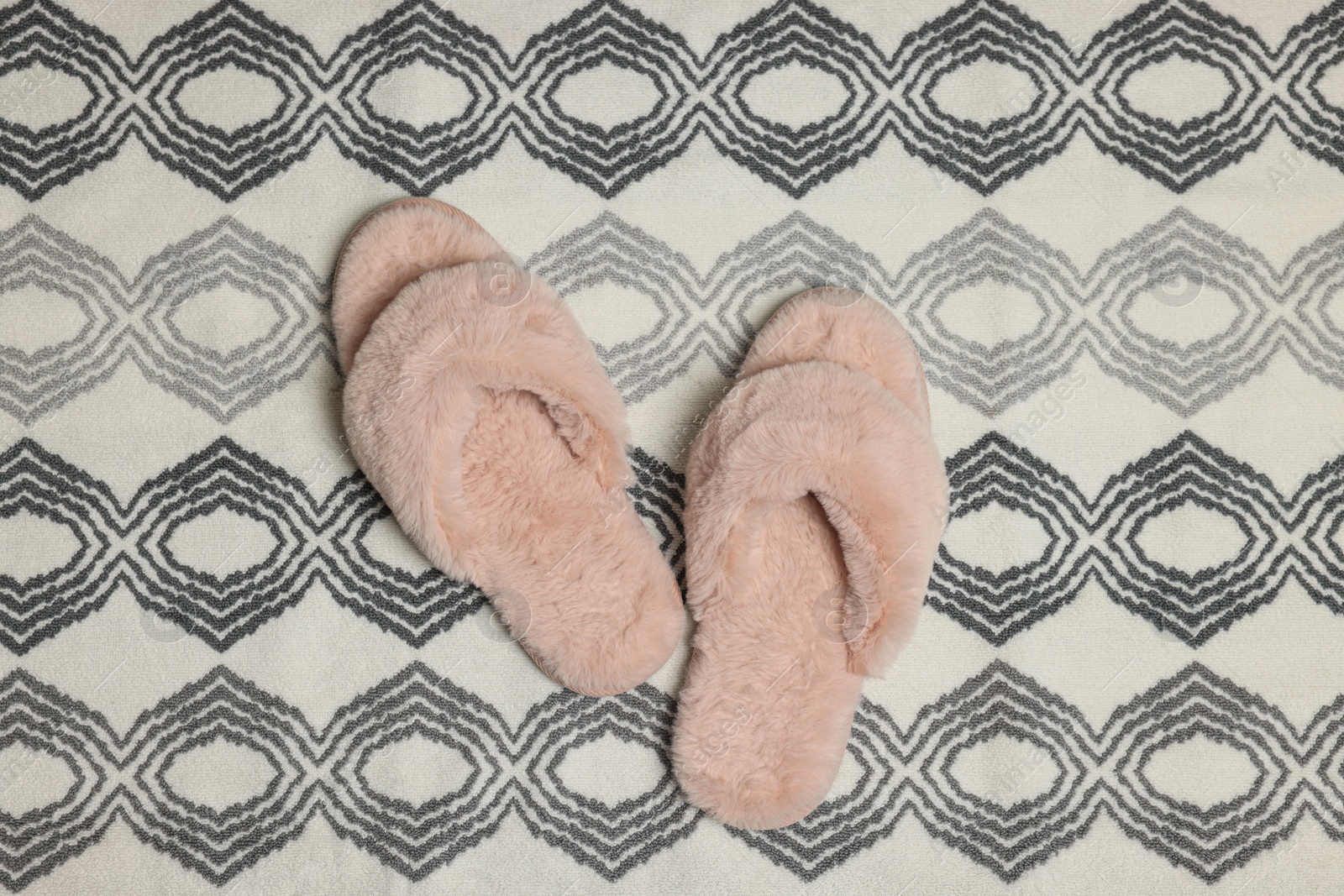 Photo of Slippers on soft bath mat, flat lay