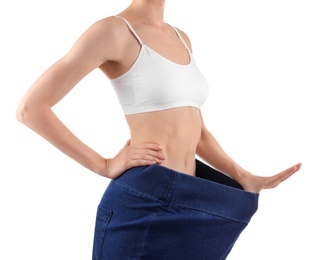 Photo of Young slim woman wearing oversized jeans on white background, closeup