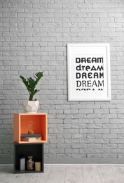 Photo of Shelves and tropical plant with green leaves near brick wall