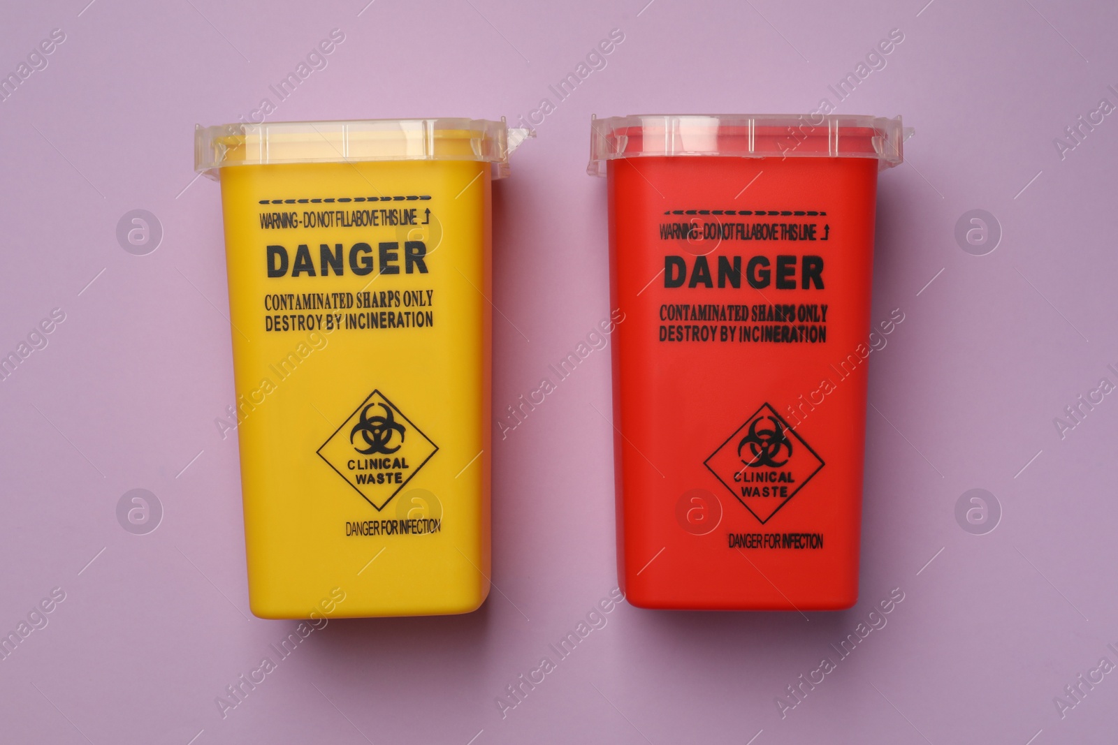 Photo of Sharps containers for used syringe on violet background, flat lay