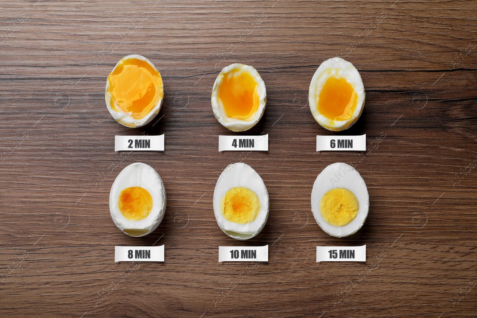 Image of Different readiness stages of boiled chicken eggs on wooden table, flat lay