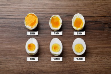 Image of Different readiness stages of boiled chicken eggs on wooden table, flat lay