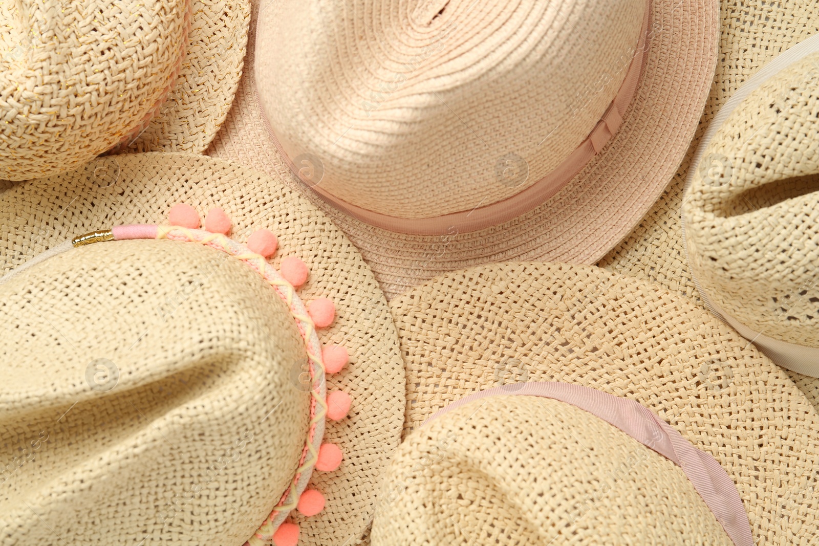 Photo of Many different straw hats as background, top view