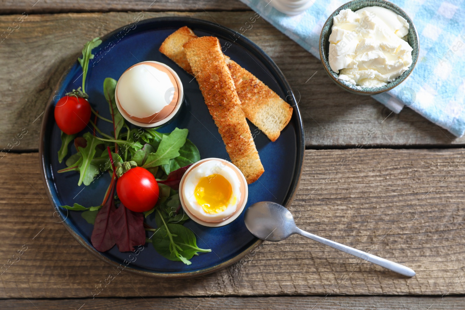 Photo of Delicious breakfast with soft boiled eggs served on wooden table, flat lay