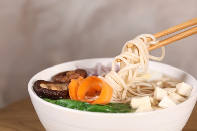 Photo of Eating delicious vegetarian ramen at table, space for text. Noodle soup