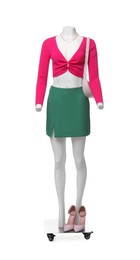 Photo of Female mannequin dressed in green skirt and pink top with accessories isolated on white. Stylish outfit