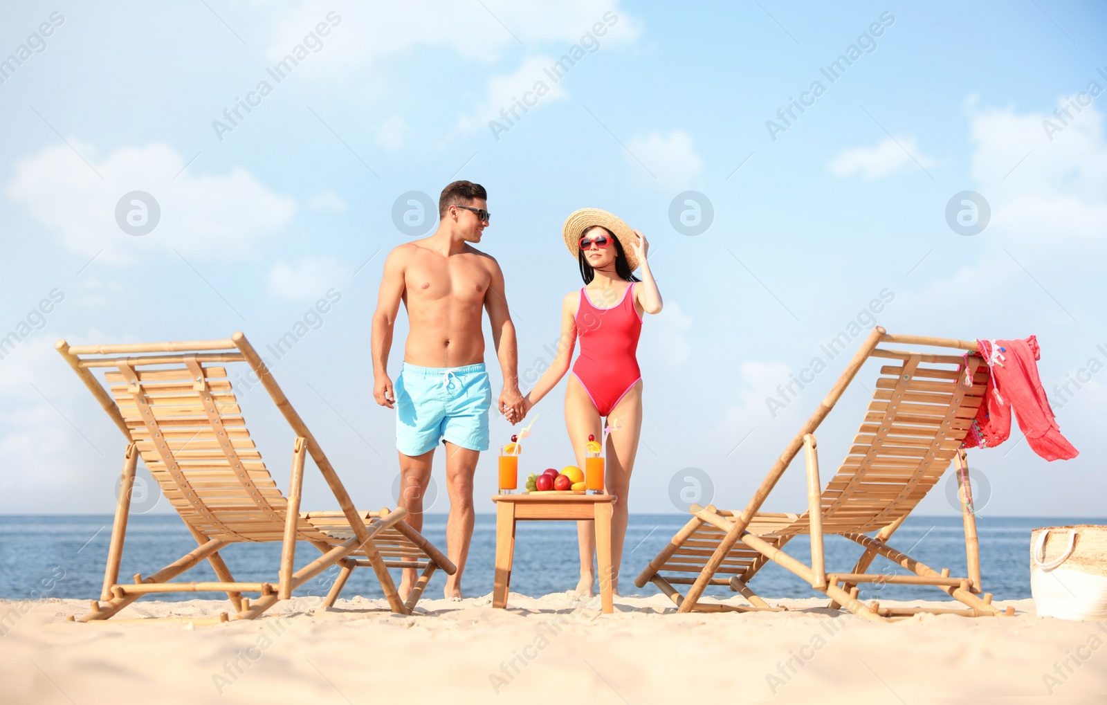 Photo of Happy couple resting on sunny beach at resort