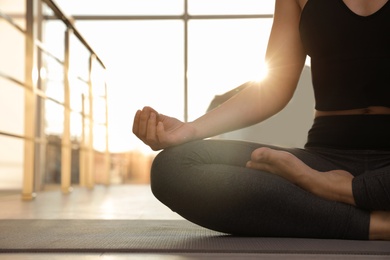 Woman practicing yoga on floor against window, closeup. Space for text