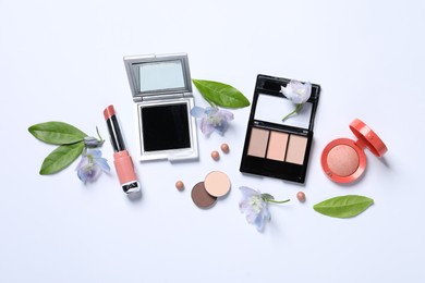 Flat lay composition with different makeup products and beautiful flowers on white background