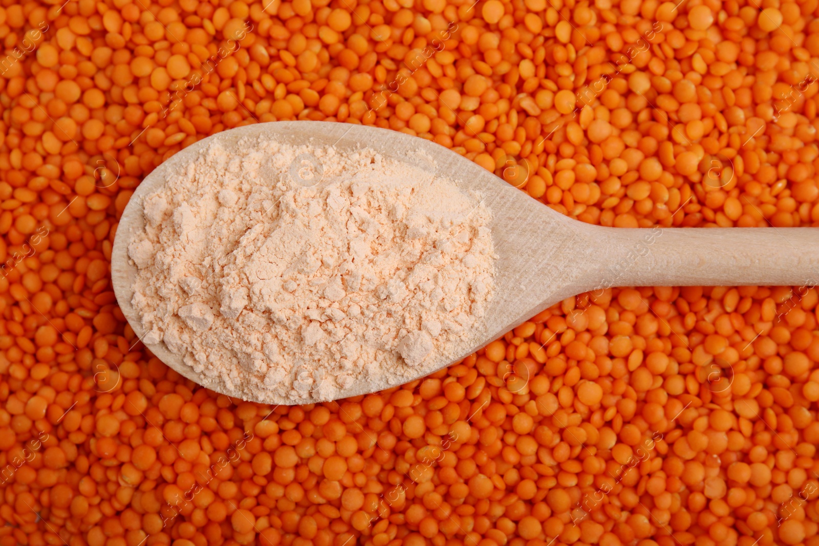 Photo of Spoon of lentil flour on seeds, closeup