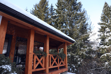 Photo of Wooden gazebo near snowy forest on winter day
