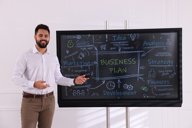 Photo of Business trainer using interactive board in meeting room