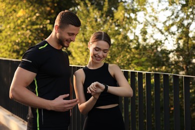 Photo of Attractive happy couple checking pulse after training in park