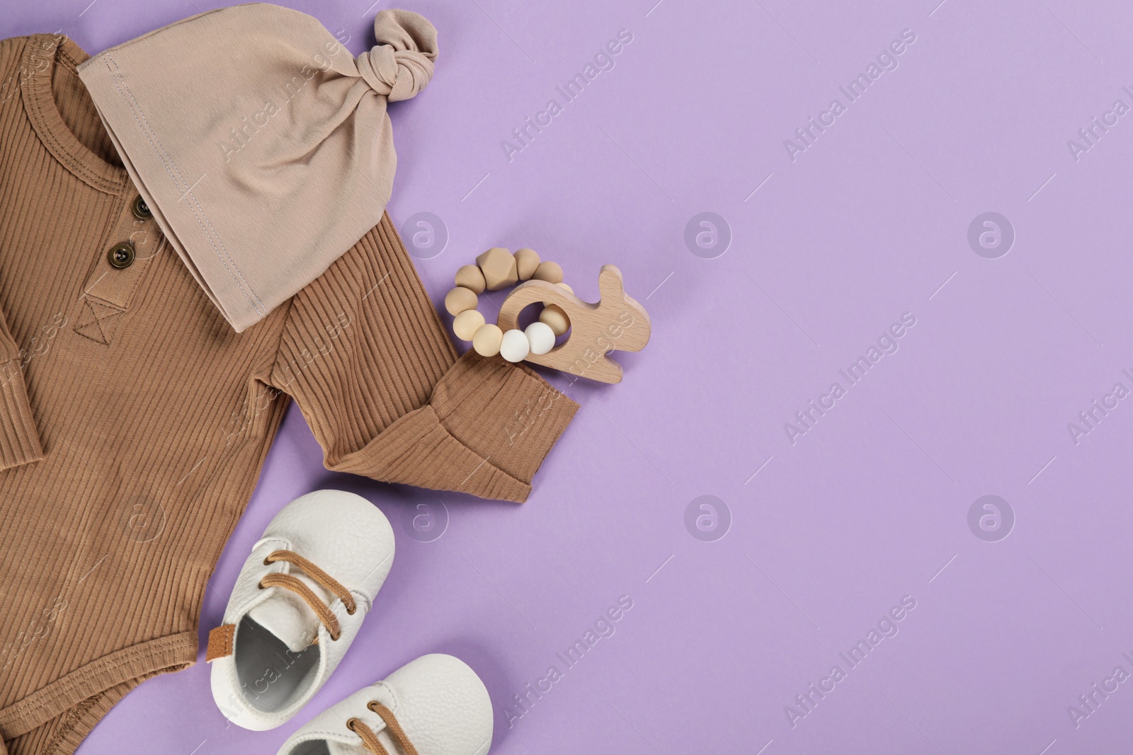 Photo of Flat lay composition with baby clothes and accessories on violet background, space for text