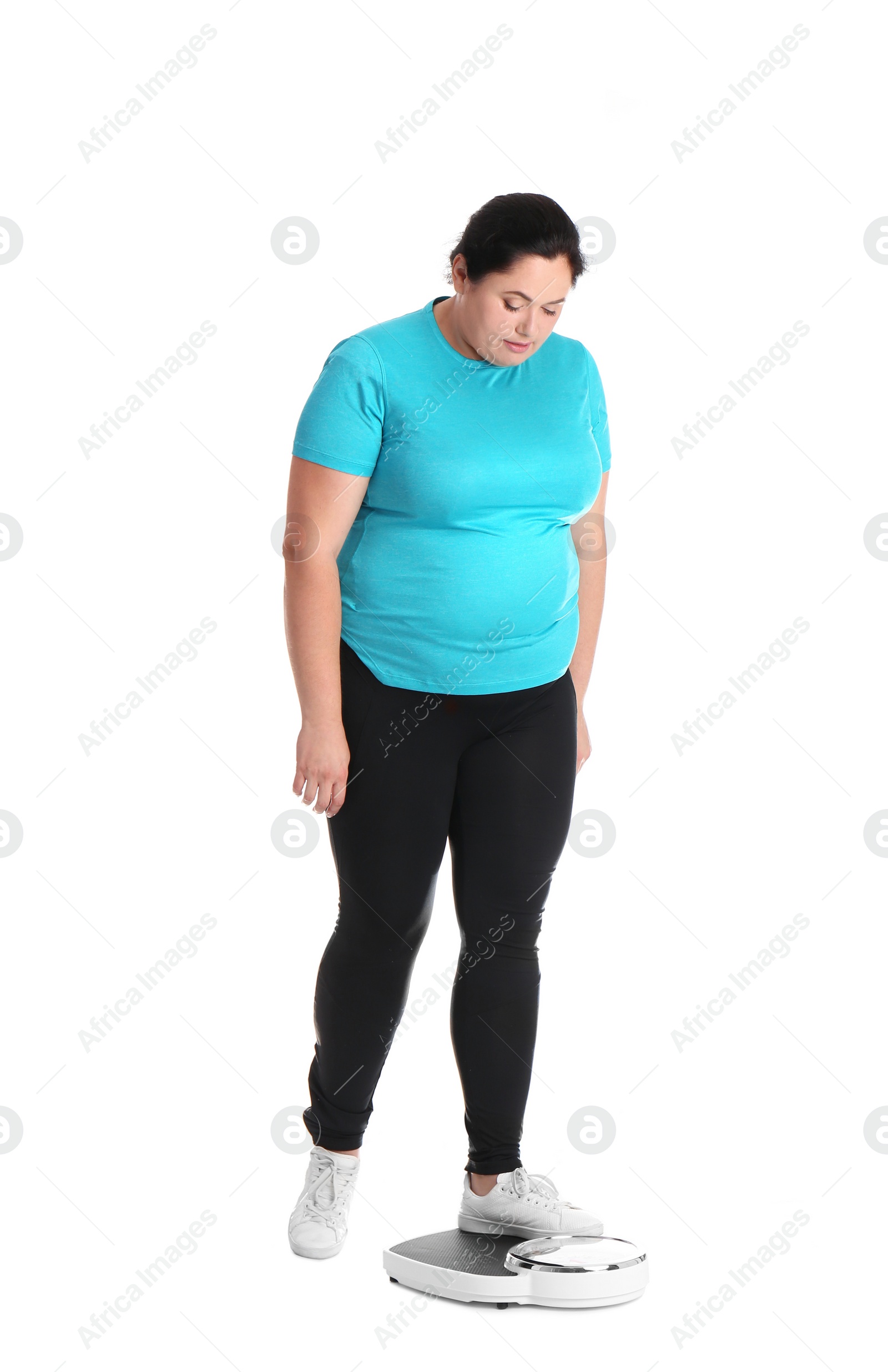 Photo of Overweight woman in sportswear using scales on white background