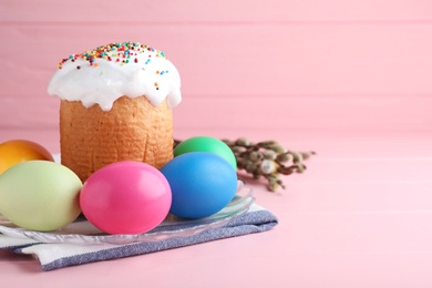 Photo of Traditional Easter cake, colorful eggs and willow branches on pink background. Space for text