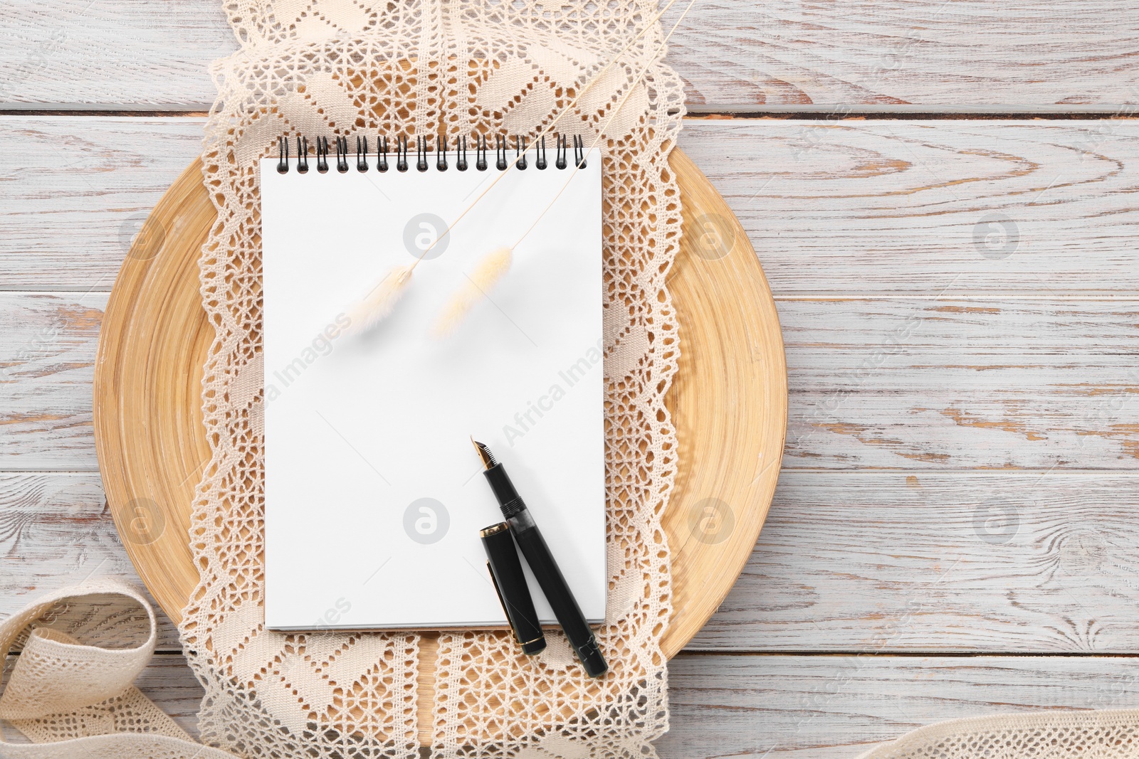 Photo of Guest list. Notebook, pen, spikelets and lace ribbons on wooden background, flat lay. Space for text