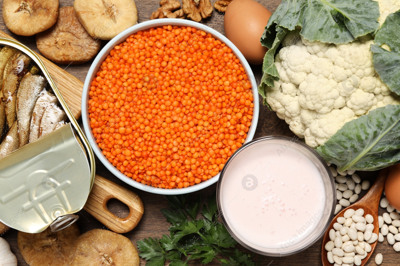 Photo of Set of natural food high in calcium on wooden table, flat lay