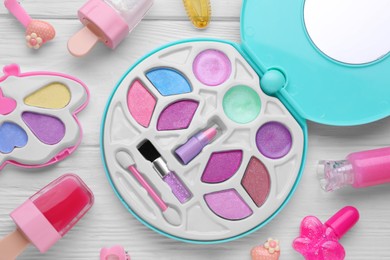 Photo of Decorative cosmetics for kids. Eye shadow palette, lipsticks and accessories on white wooden table, flat lay
