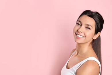 Young woman with healthy teeth on color background. Space for text