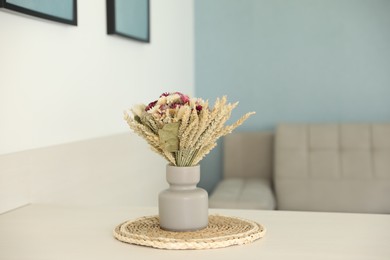 Beautiful bouquet of dry flowers on white table indoors, space for text