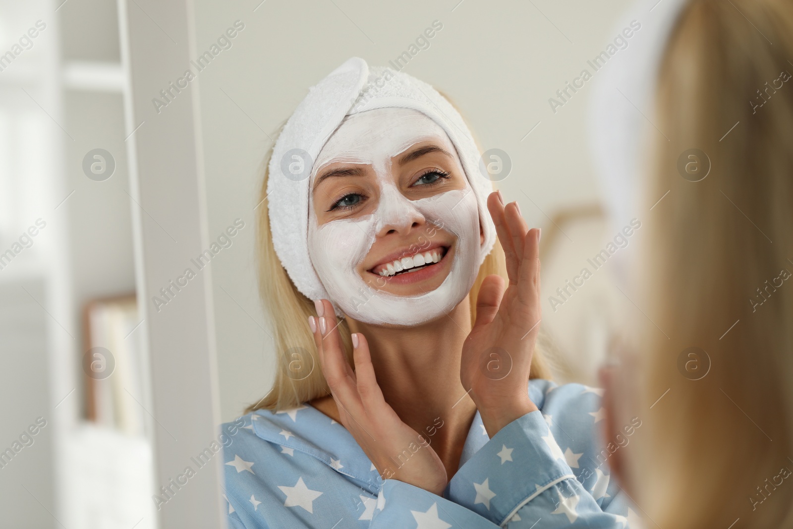 Photo of Young woman applying face mask at home. Spa treatments