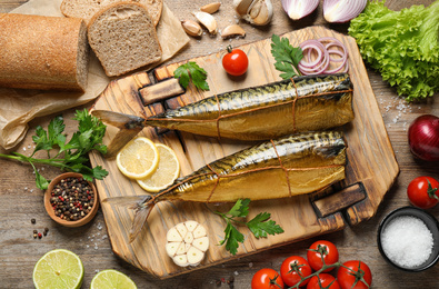 Flat lay composition with tasty smoked fish on wooden table