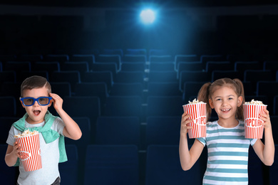 Image of Cute little children with popcorn in cinema hall