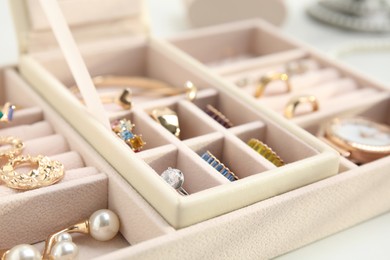 Photo of Jewelry box with stylish golden bijouterie on white table, closeup