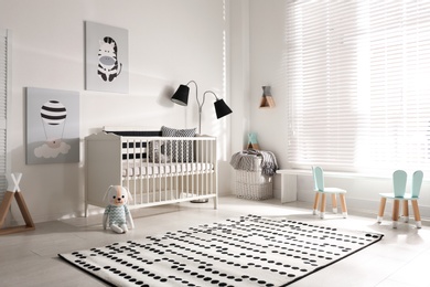Photo of Cute baby room interior with crib and decor elements
