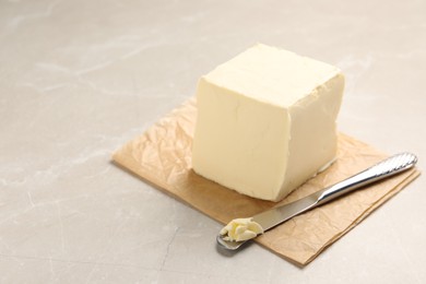 Photo of Block of tasty butter and knife on light table. Space for text