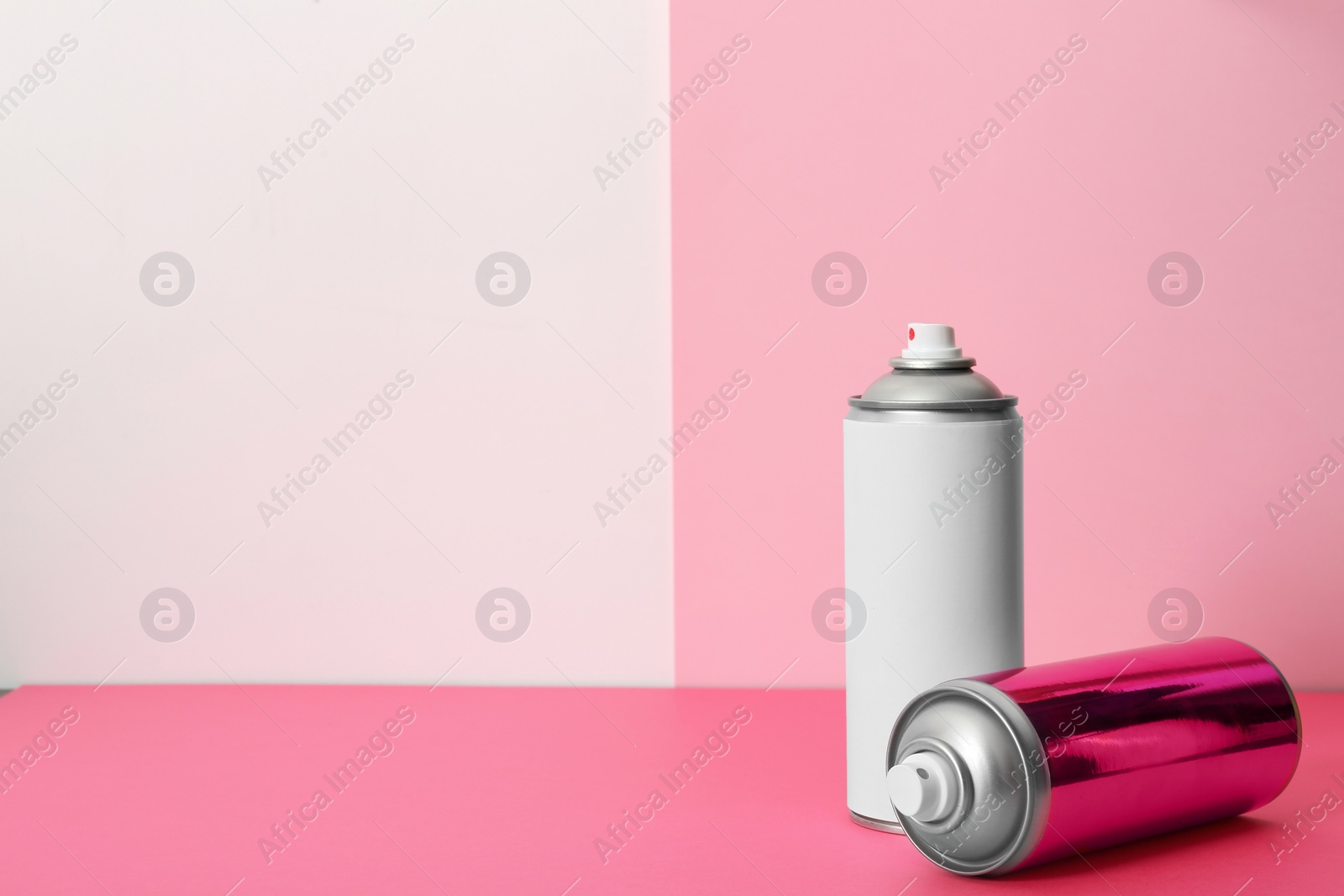 Photo of Cans of different spray paints on color background. Space for text