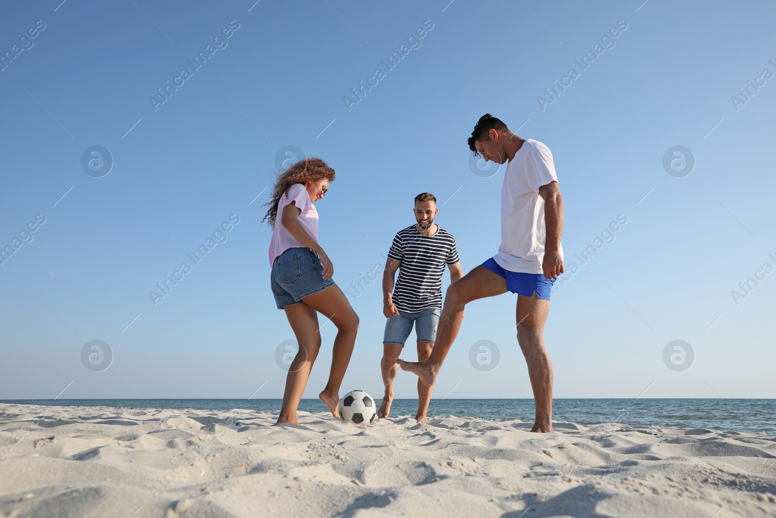 Photo of Group of friends playing football on beach