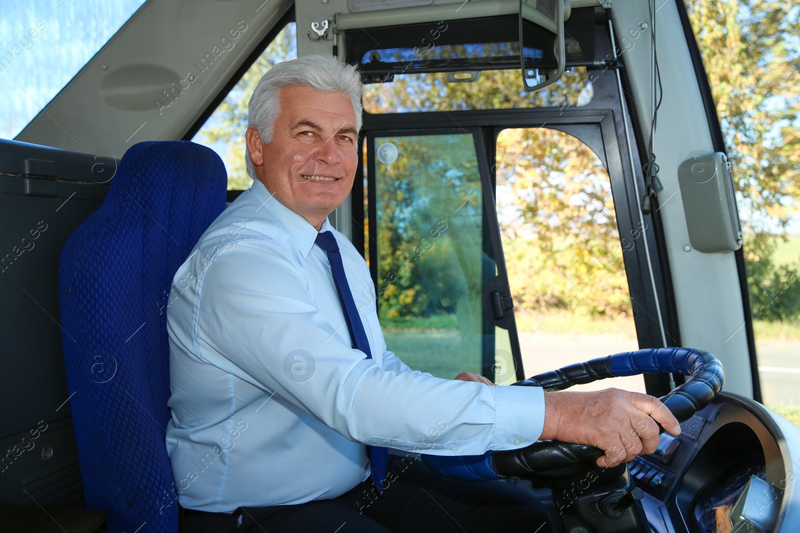 Photo of Professional bus driver at steering wheel. Passenger transportation
