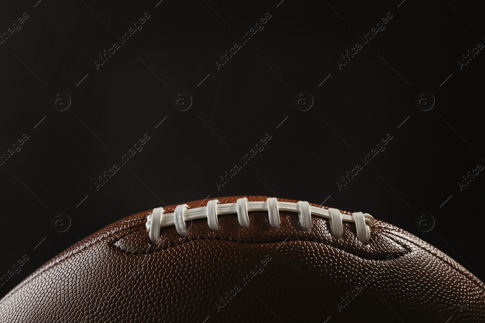 Photo of New American football ball on dark background