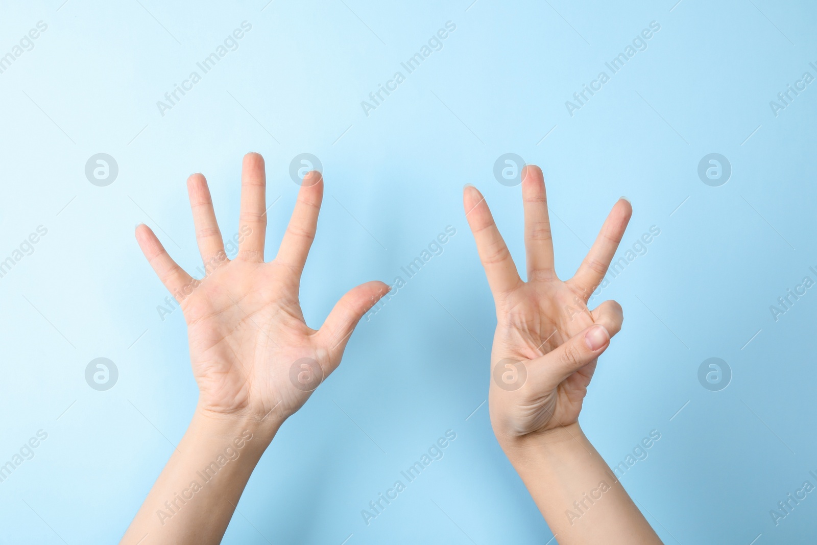 Photo of Woman showing sign eight on color background, closeup. Body language